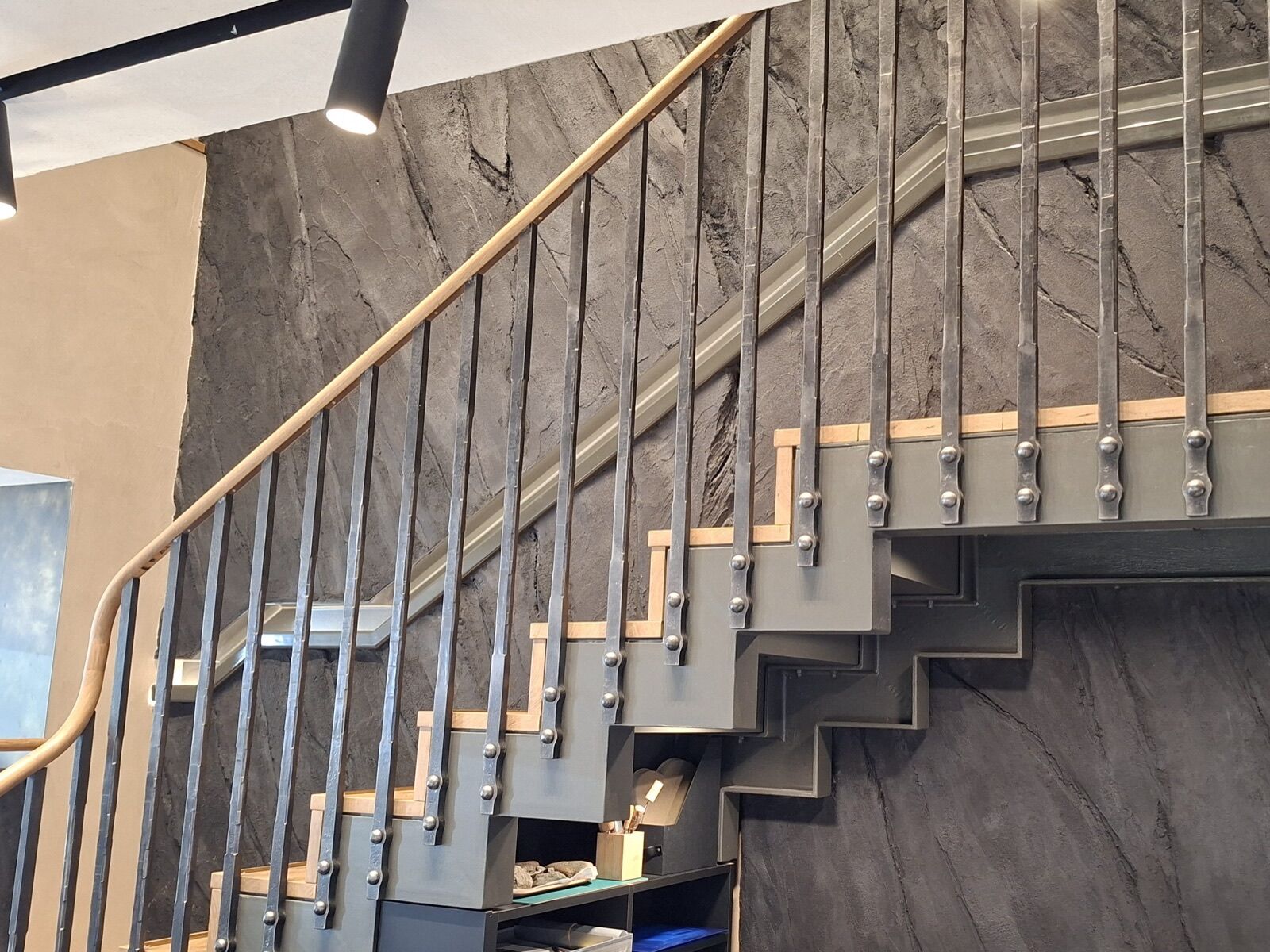 Curved metal staircase with a timber handrail, shown in Blotnicki Metal Design's fabrication portfolio