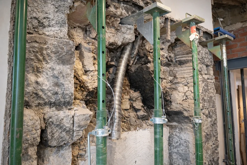 Temporary supports beside exposed masonry during structural work