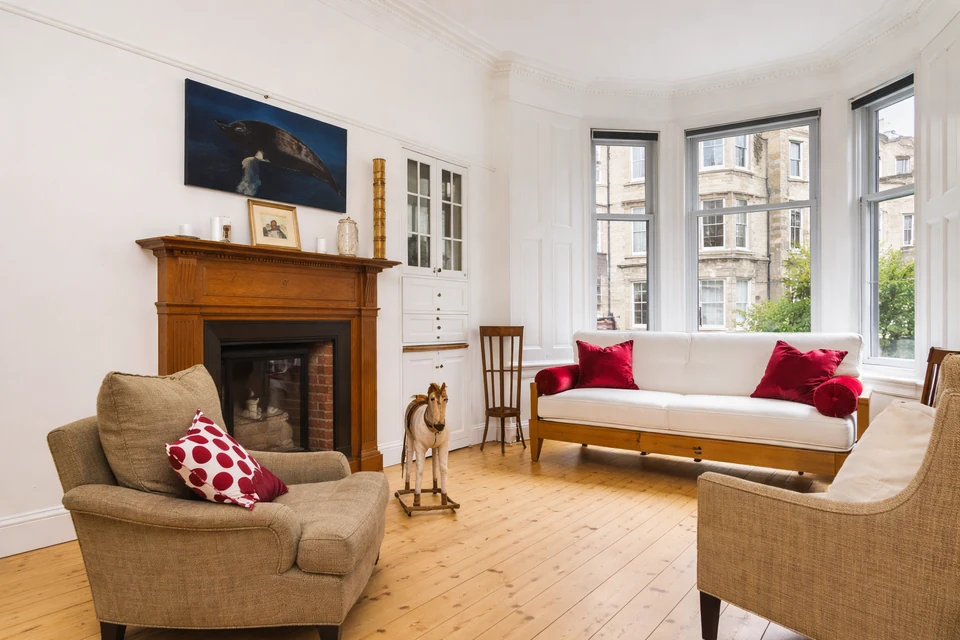 Period living room with fireplace and bay window