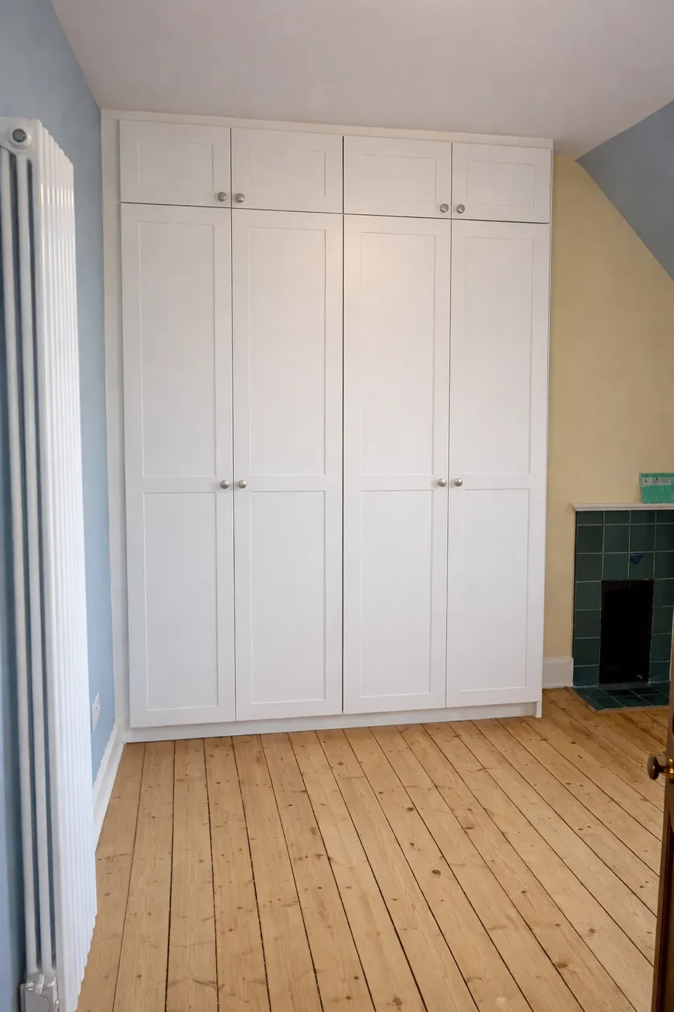 White fitted wardrobe doors beside a window.